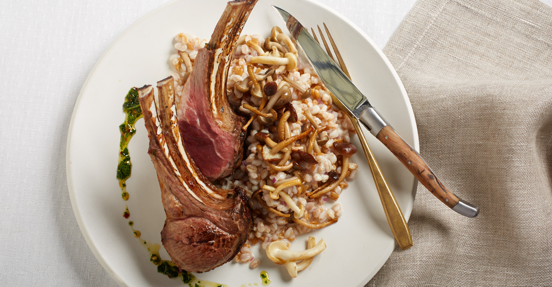 A plate with lamb chops and rice on it